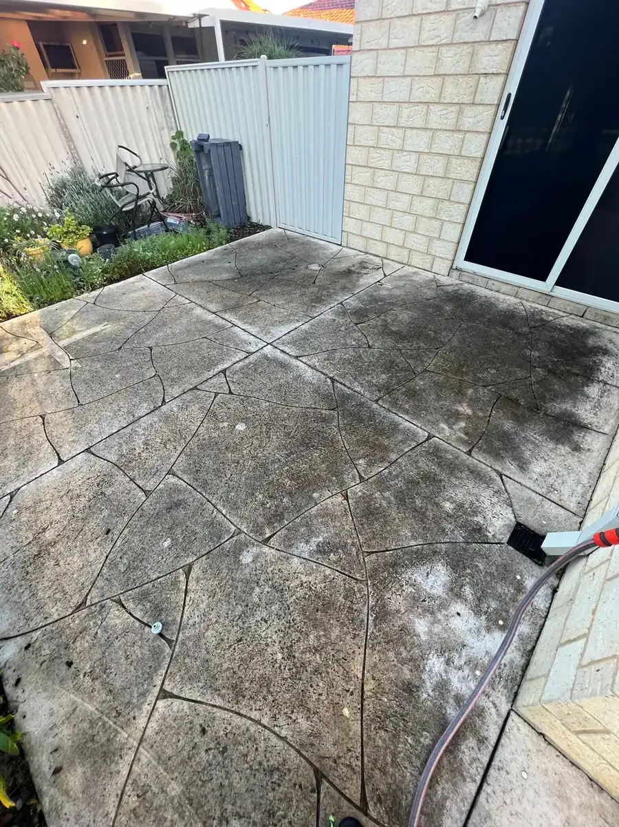 Crazy-paved limestone before cleaning, blackened with lichen