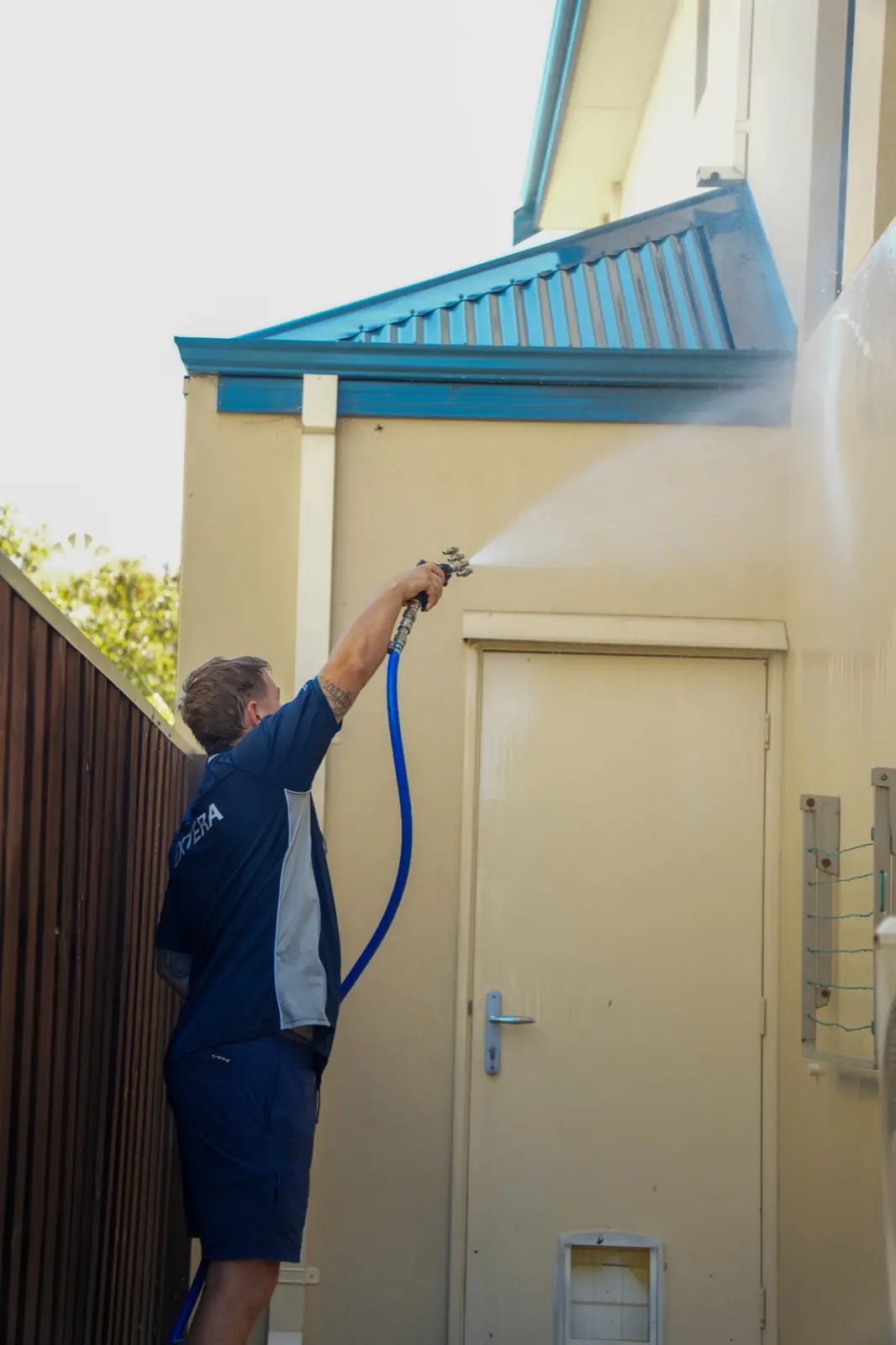 Extera operator soft washing a Perth house exterior
